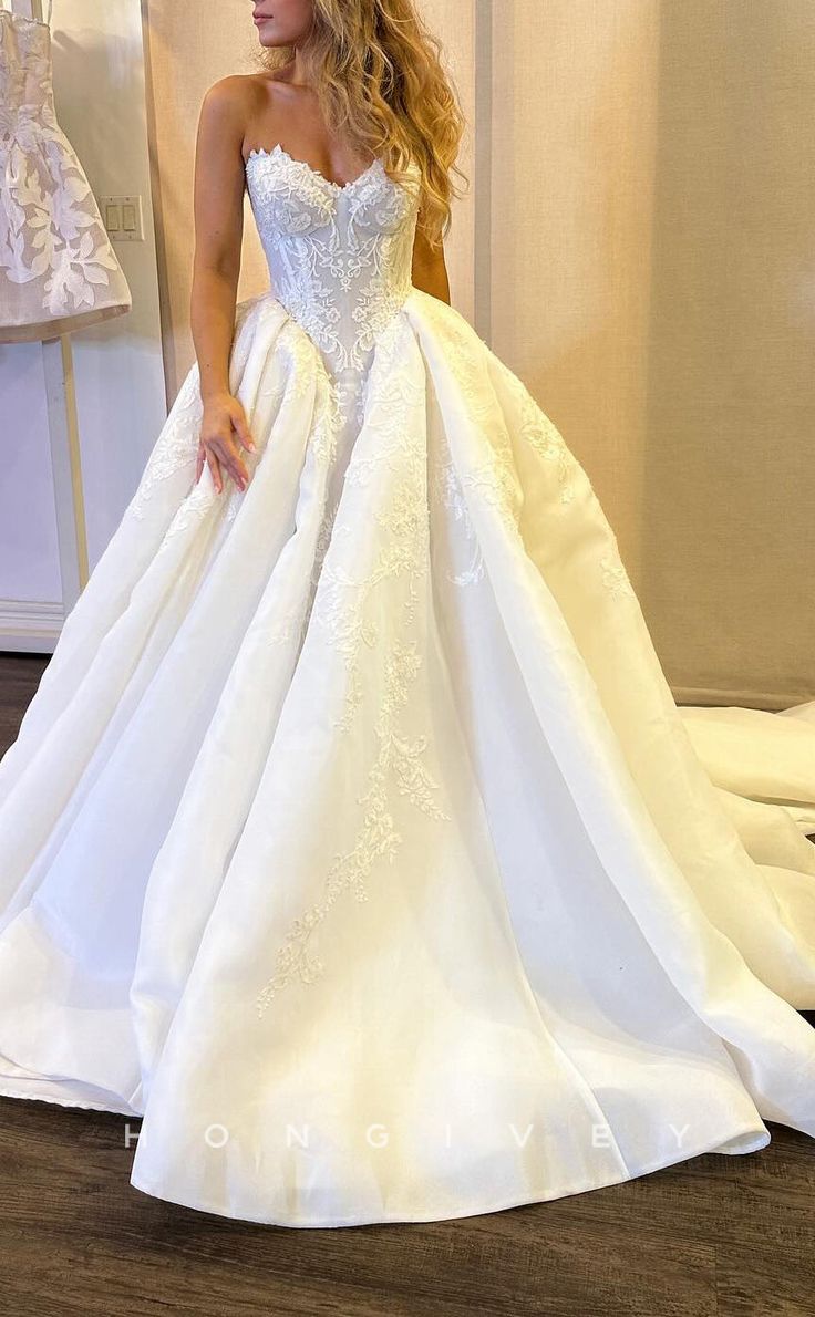 a woman in a white wedding dress standing next to a rack with dresses on it