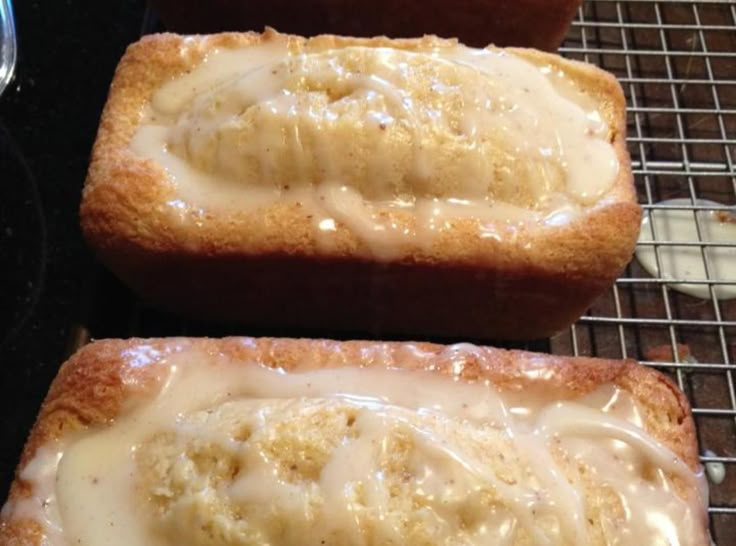 two pieces of bread covered in icing sitting on a cooling rack