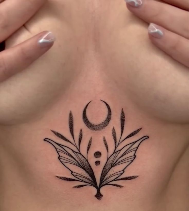 a woman's chest with an artistic tattoo on it