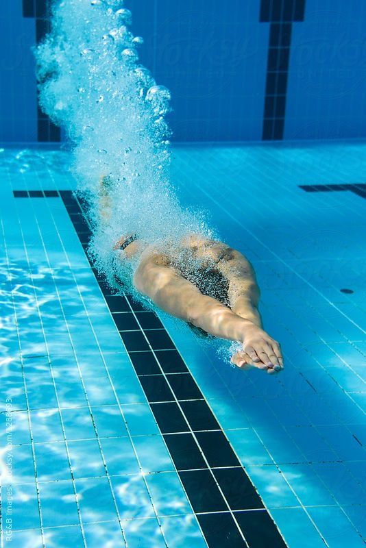 a man swimming in a pool with his back to the camera