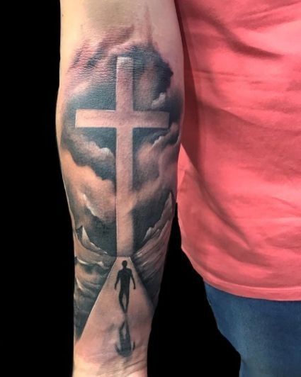 a person with a cross tattoo on their arm