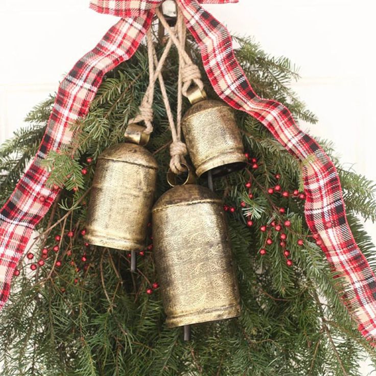 a christmas wreath with three bells hanging from it