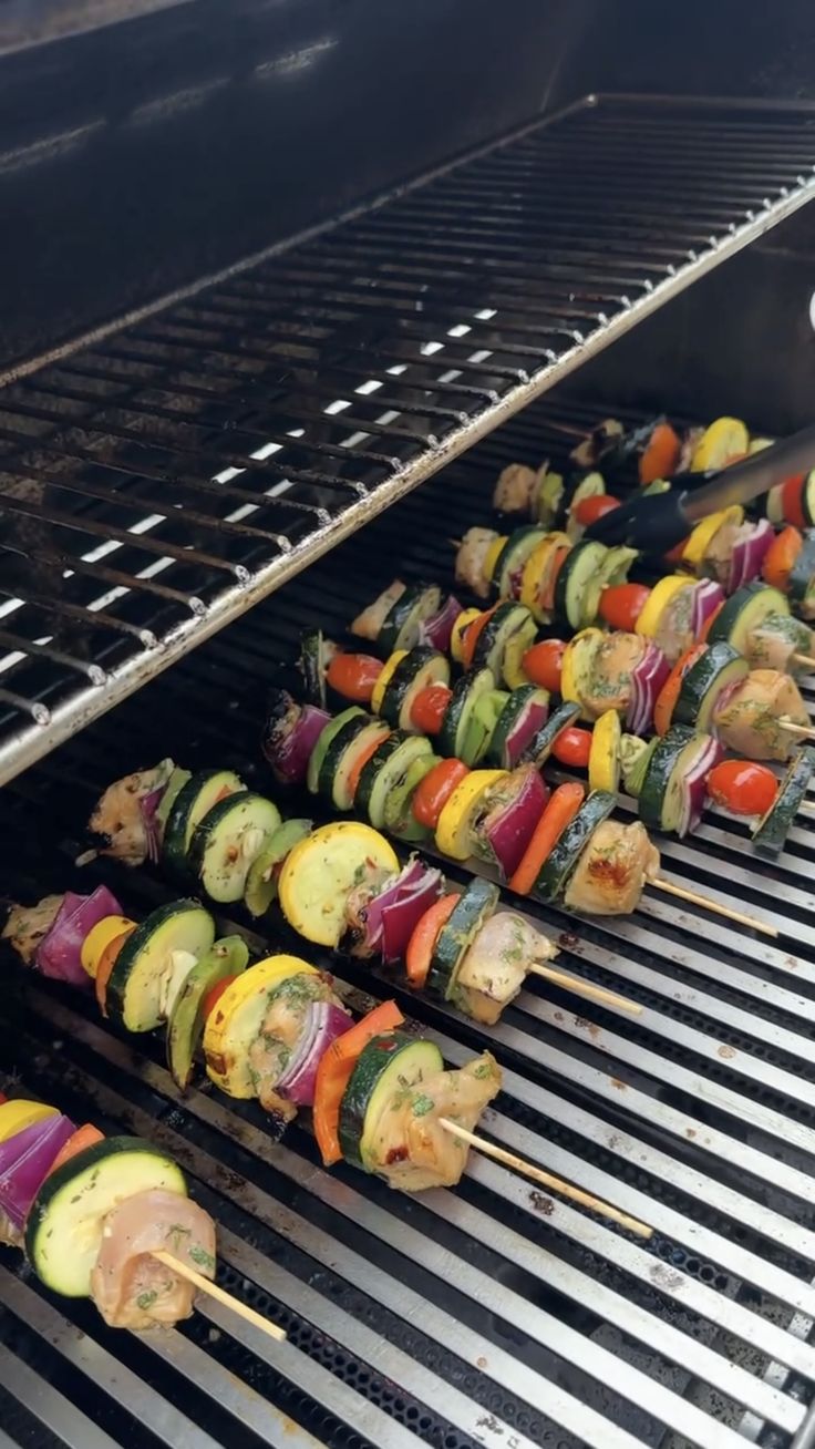 several skewered vegetables are being cooked on the grill