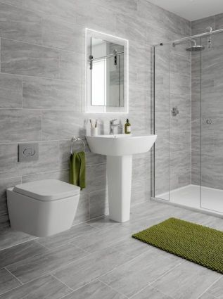 a bathroom with a sink, toilet and shower stall in grey marbled finish tiles