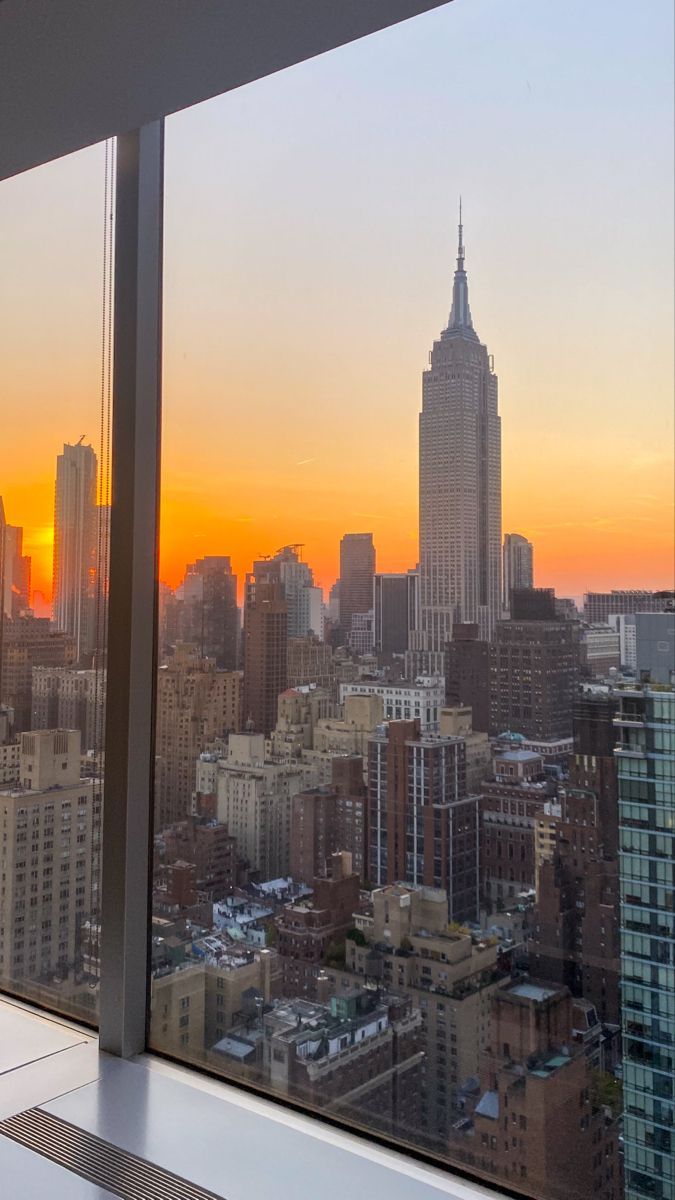 the sun is setting over new york city as seen from an observation deck at one world trade center