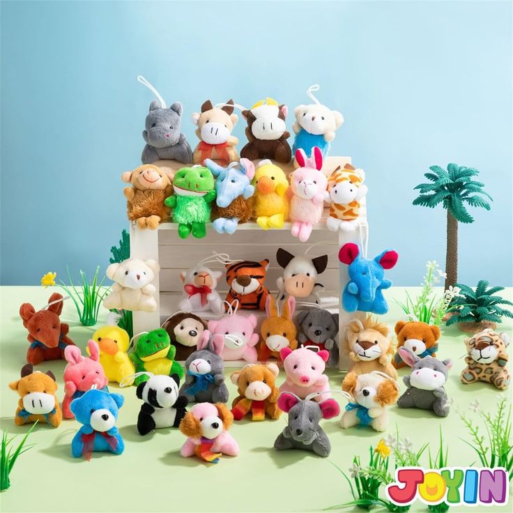 there are many small stuffed animals in the toy house with grass and palm trees behind them