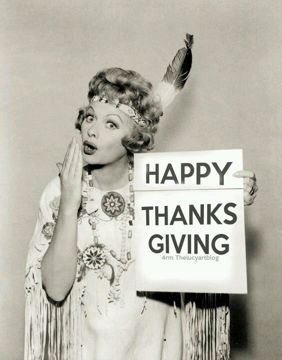 a woman holding a sign that says happy thanks giving with feathers on her head and hands