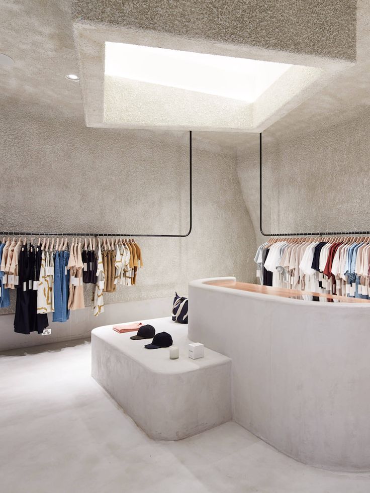 an empty clothing store with clothes hanging on racks and shoes in the foreground,