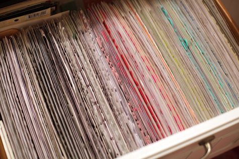 an open file cabinet filled with lots of papers on top of each other in different colors