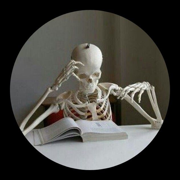 a skeleton sitting at a table with an open book in front of it, reading