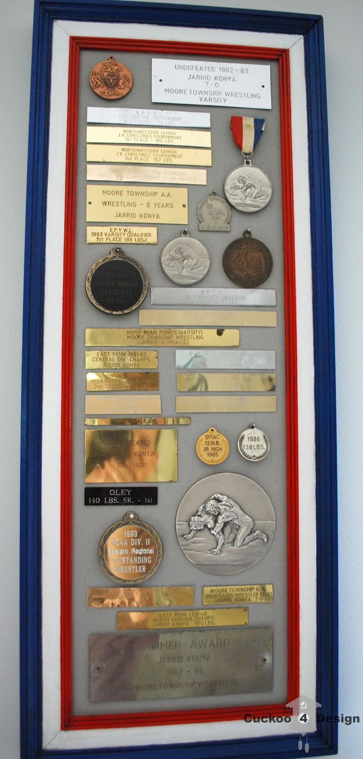 a framed display with medals and other items on it's side, in a blue frame