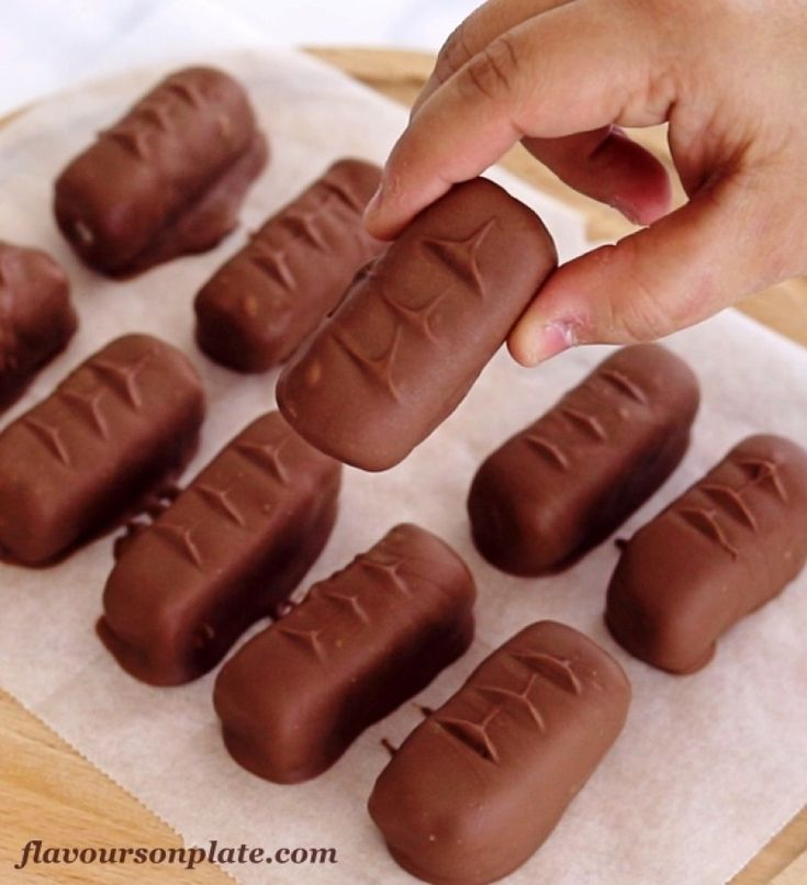 a person picking up some chocolate from a tray