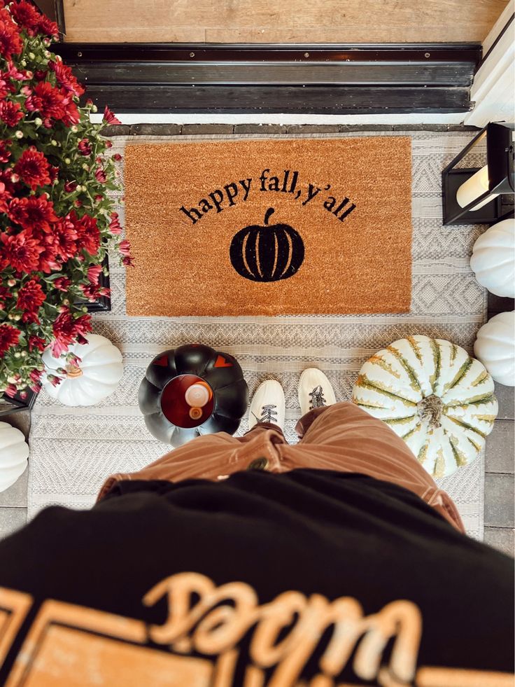 a door mat that says happy fall and pumpkins