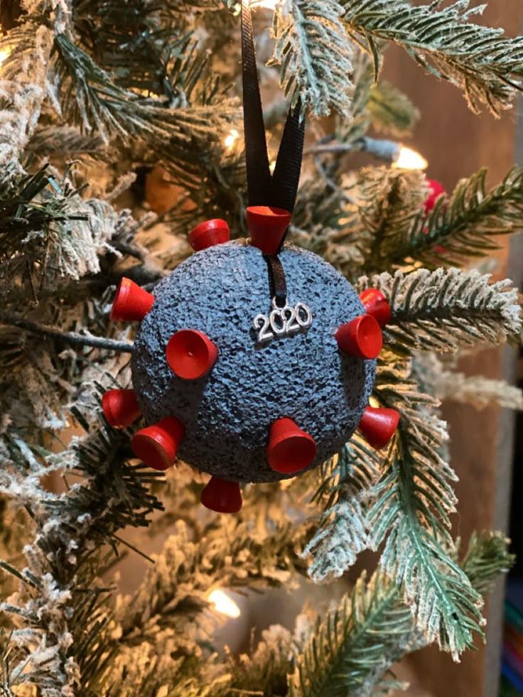 a blue ornament hanging from a christmas tree decorated with red and white decorations