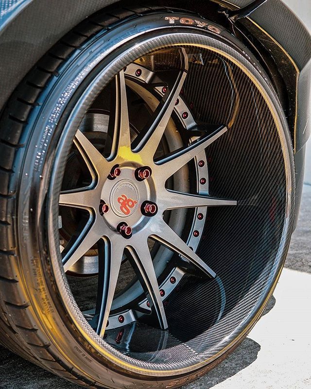 the front wheel of a sports car with chrome spokes