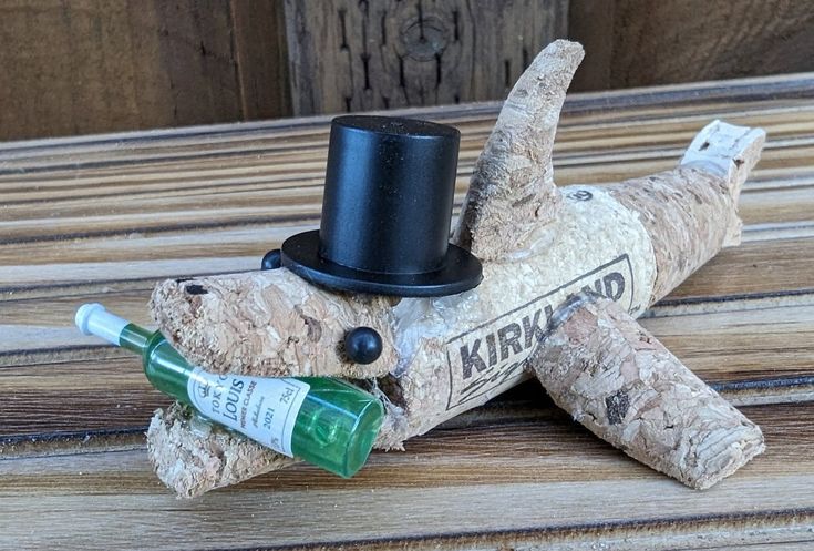 a wooden dog with a top hat and green bottle