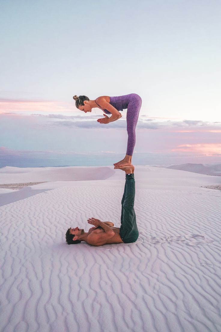 a man and woman doing yoga in the desert