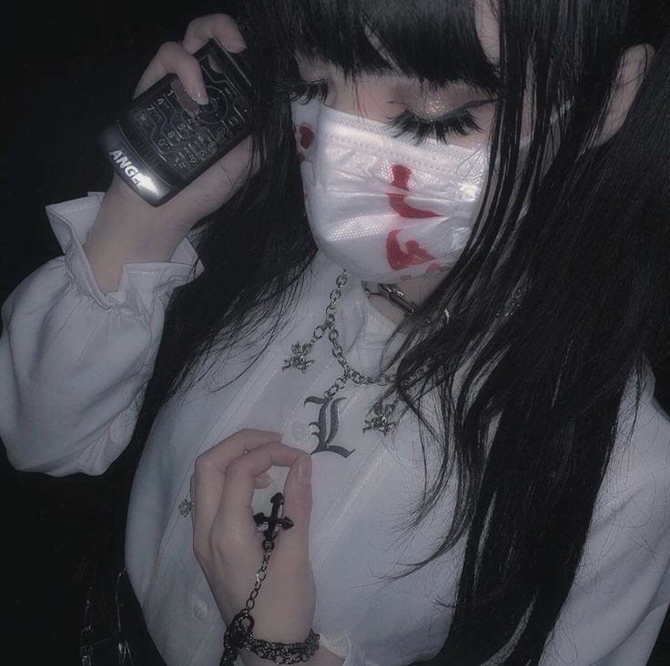 a woman wearing a white shirt and holding a cell phone to her face with blood on it