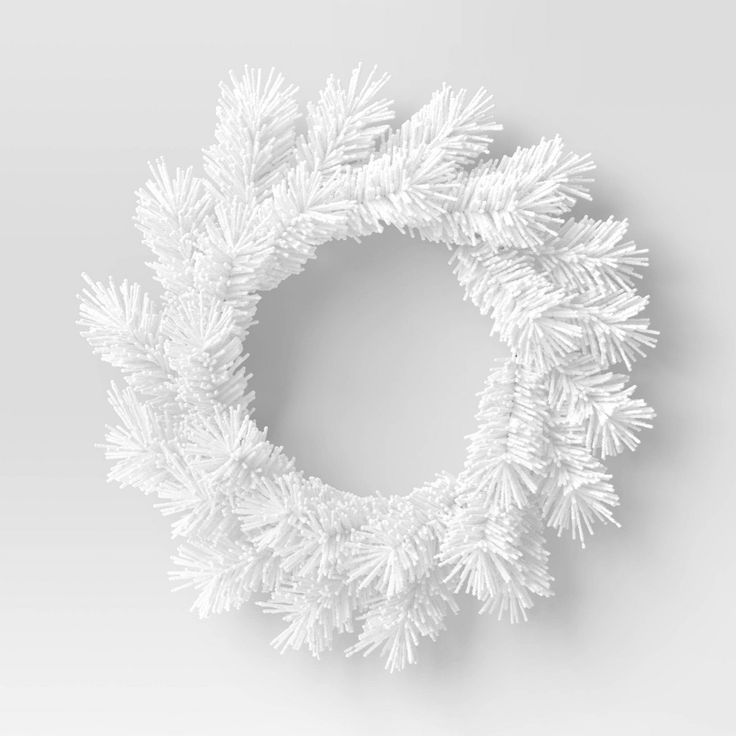 a white christmas wreath with snow flakes hanging from it's sides on a gray background