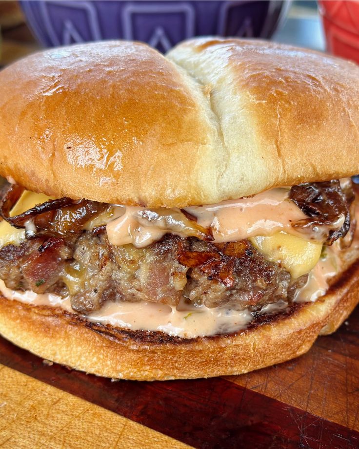 a close up of a hamburger on a wooden table