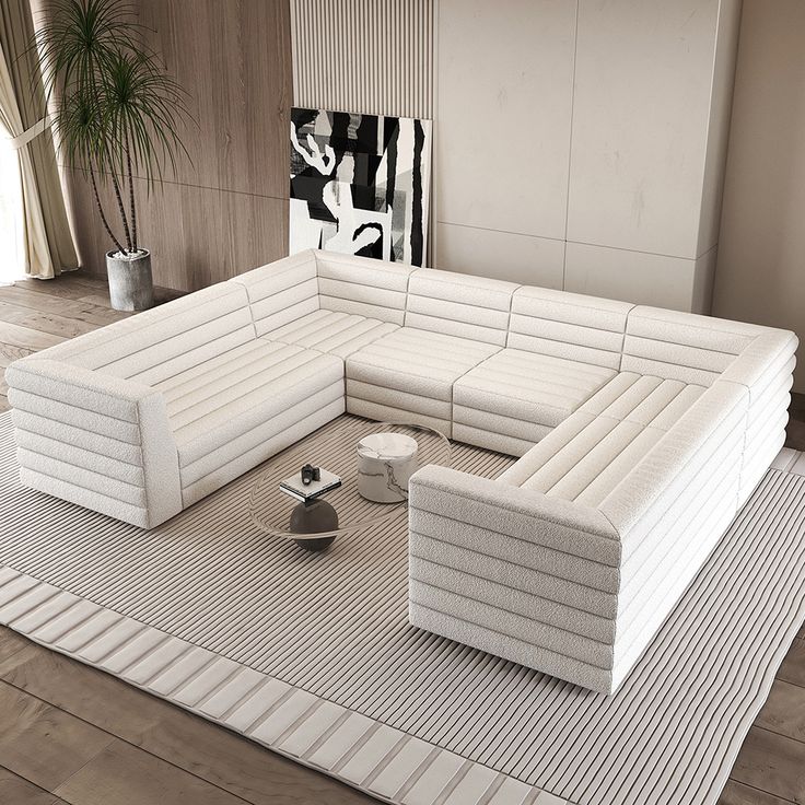 a large white couch sitting on top of a rug in a living room next to a potted plant