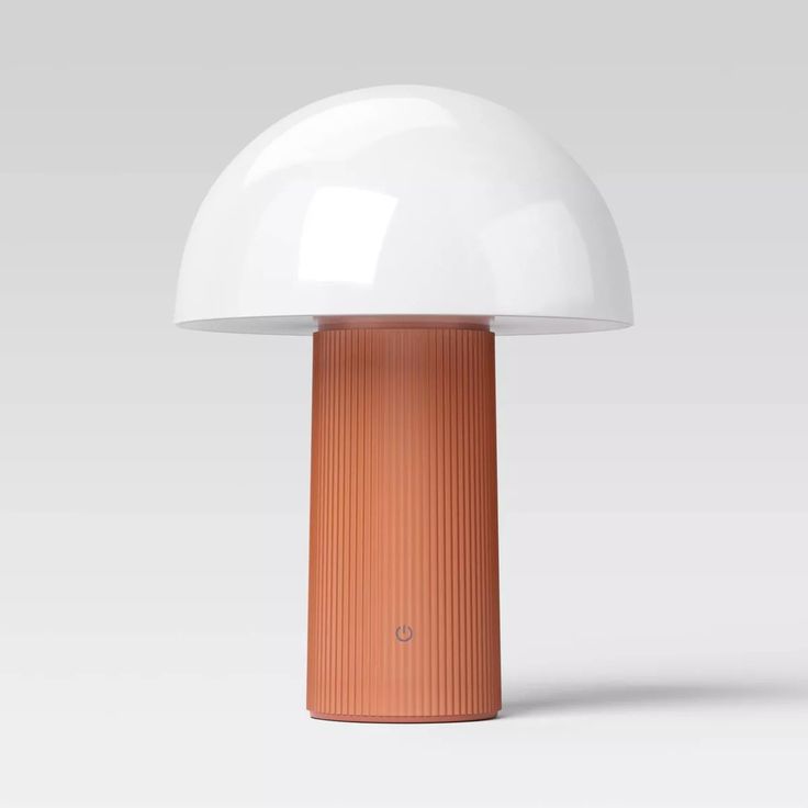 an orange and white lamp sitting on top of a table