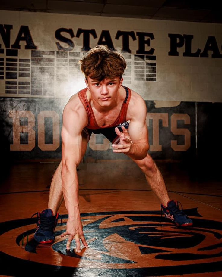 a man doing push ups on a wrestling mat