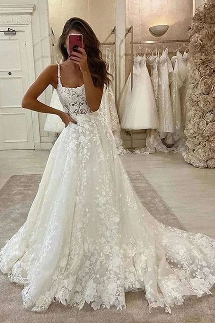 a woman is taking a selfie in her wedding dress while looking at her phone