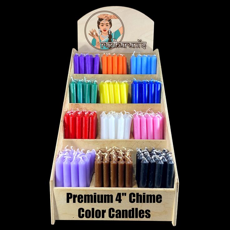 a display case filled with lots of different colored candle sticks in front of a black background