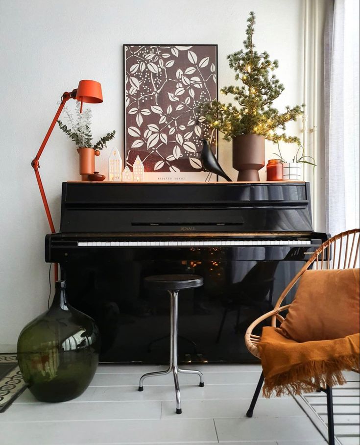 a living room with a black piano in the corner and some plants on top of it