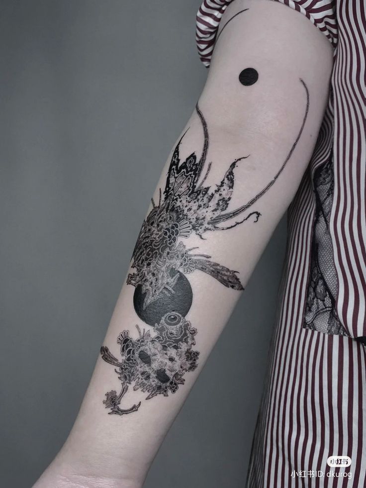 a woman's arm with an octopus and flowers tattoo on the left inner arm