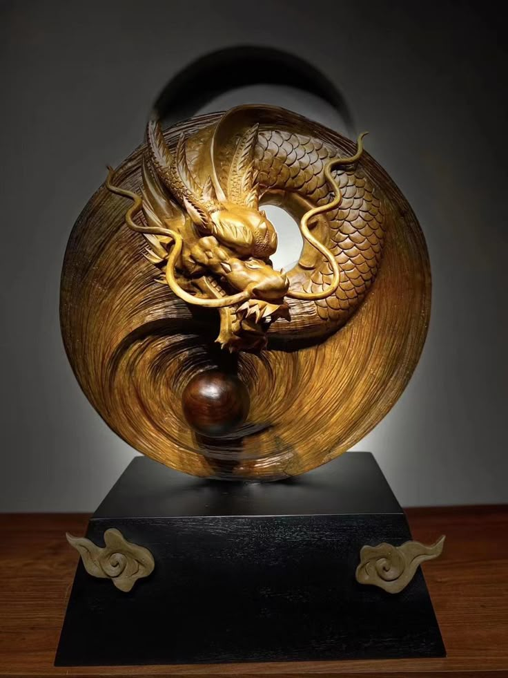 a golden dragon sculpture sitting on top of a wooden table