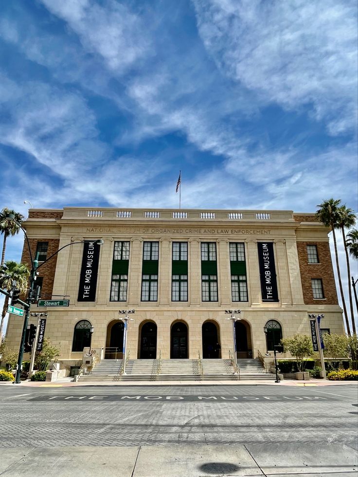 an old building with palm trees on the side and blue sky in the back ground