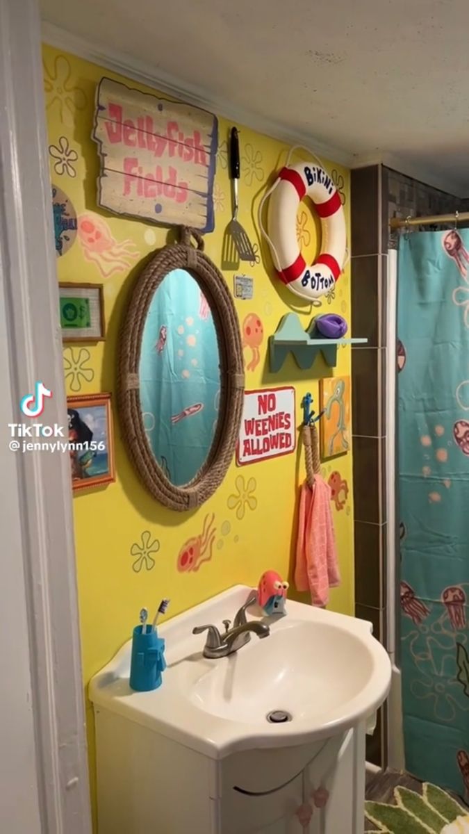 the bathroom is decorated in bright colors and has pictures on the wall above the sink