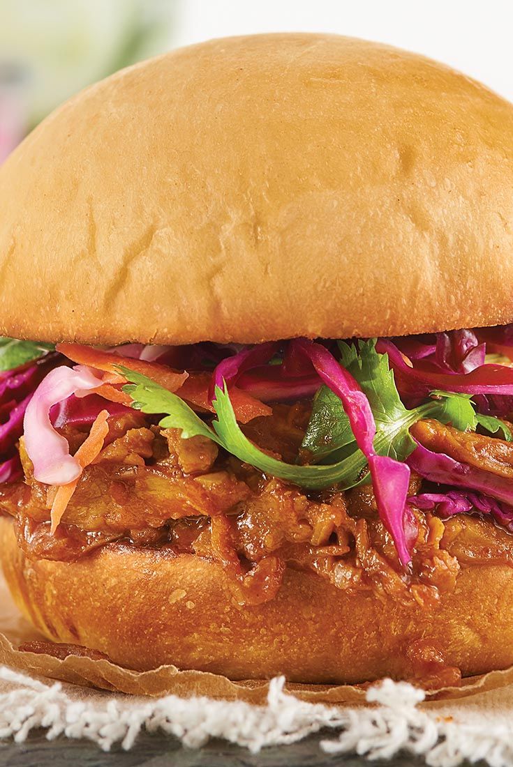 a pulled pork sandwich with cole slaw and lettuce