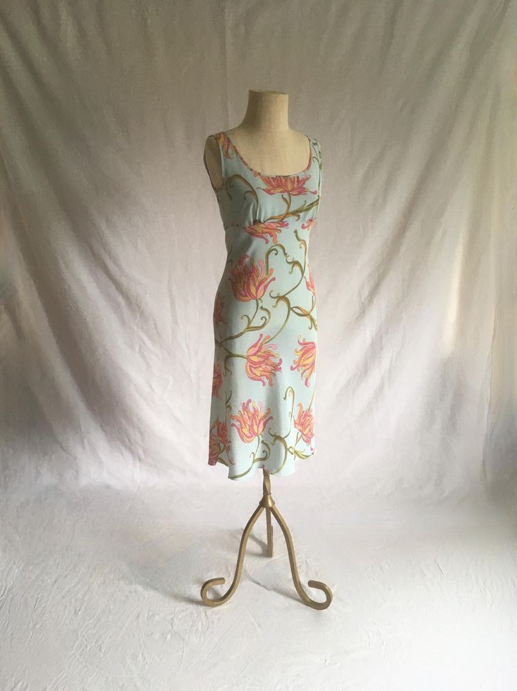 vintage 1990s dress no tags but other same dress found w/label- Speechless semi sheer polyester unlined high waist tie back pullover sleeveless light blue w/pink, green, orange, yellow, black  floral pattern (an ode to Emilio Pucci sweeping floral patterns) good vintage condition, light wear no size tag-see below measures, lying flat, shoulder-13 1/2" chest-17" to 17 1/2" w/pleated room waist-15" hip-18 1/2" to 20" top to waist-11 1/4" total length-41 1/2" Fitted Midi Dress With Tie Back, Fitted V-neck Dress For Daywear, Fitted Summer Dress With Spaghetti Straps, Spring Stretch Dress With Tie Back, Casual Stretch Dress With Square Neck, Casual Square Neck Stretch Dress, V-neck Fitted Dress With Tie Back, Fitted Beach Dress With Lined Bodice, Stretch Mid-length Summer Dress