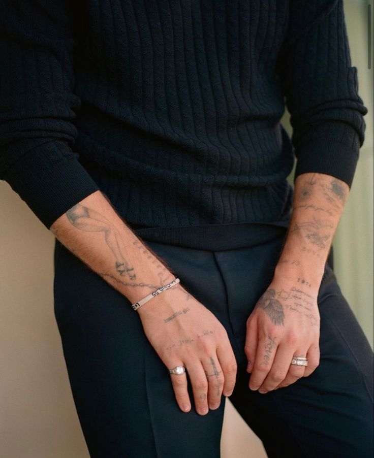 a man with tattoos on his arm sitting down