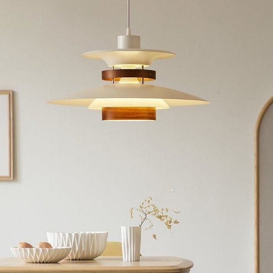 a dining room table with bowls on it and two lights hanging from the ceiling above