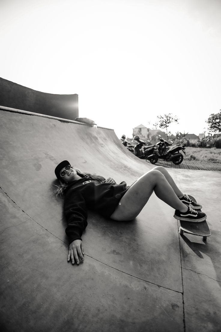 a person laying down on a skateboard in the middle of a ramp