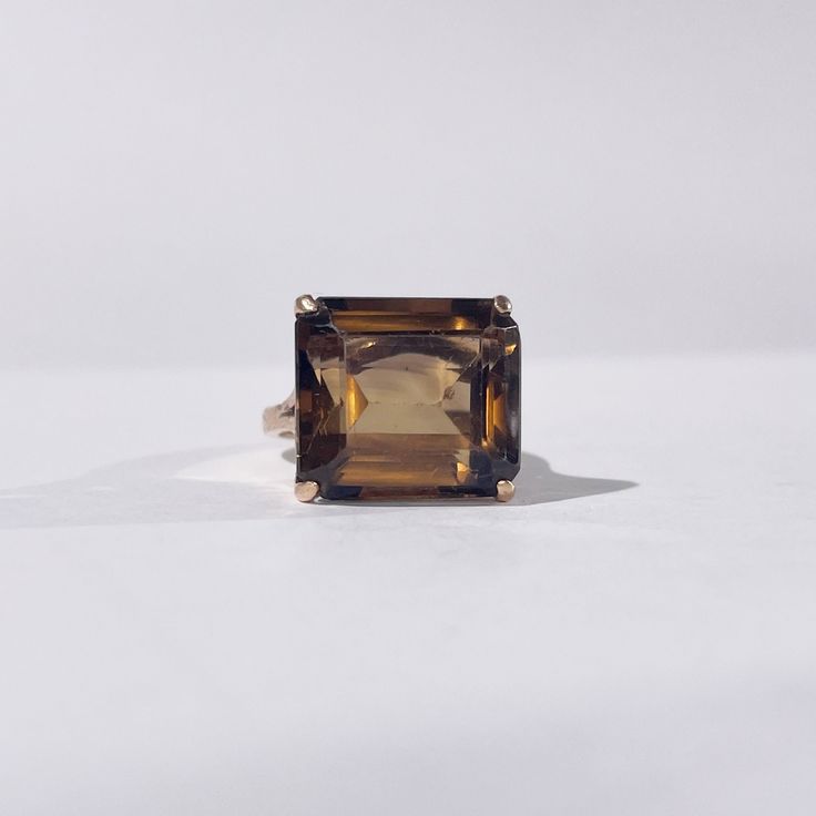 Find it on our website with a discount and resizing option: https://onisi-paris.com/en/product/gold-and-smoky-topaz-ring-meredith/ Impressive cocktail ring from the 1950s in 14k gold set with a sublime 8 carat emerald-cut smoky topaz. A sublime piece with a dark and subtle colour, enhanced by the warmth of yellow gold. Note that the corners of the stone present faint damage. Weight: 5.65g Size: FR 49/ UK K / US 5.5 The story: The cocktail ring was born with Prohibition in 1920. With the ban on the sale of alcohol in the United States, cocktails were born, a mixture of contraband alcohol, undrinkable on its own, with sugar and other ingredients to hide its taste. The bars, called speakeasys, were mostly frequented by men and a few emancipated women, the Flapper girls. The latter, to draw at Smoky Topaz Ring, Fine Jewelry 14k Gold Brown Ring, Brown 14k Gold Rings Fine Jewelry, Brown 14k Gold Fine Jewelry Ring, Elegant Brown Rings For Formal Occasions, Brown Gemstone Rings In 14k Gold, Elegant Smoky Quartz Brown Rings, Formal Brown 14k Gold Rings, Elegant Smoky Quartz Gemstone Rings