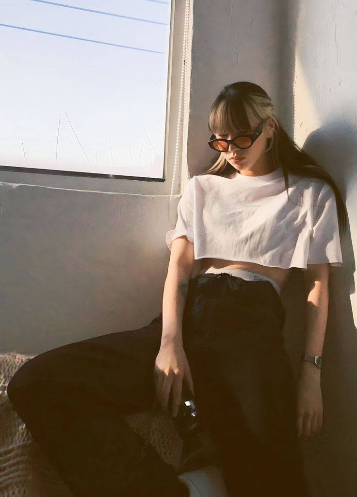 a woman sitting on top of a bed next to a window