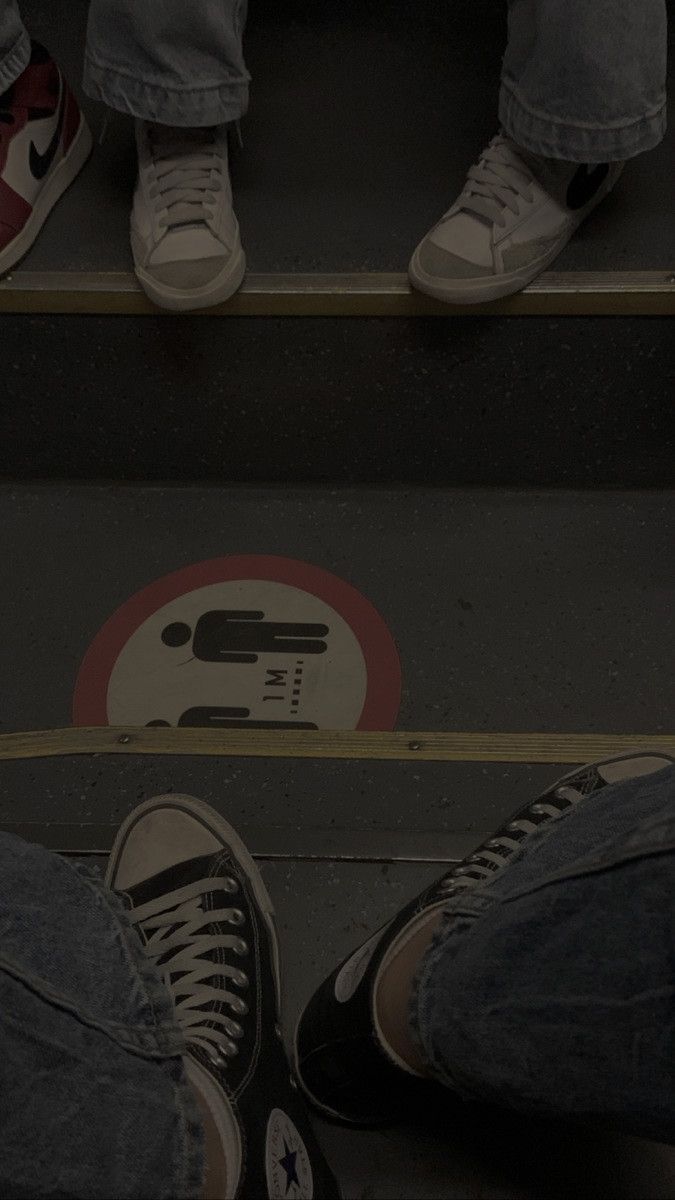 two people standing on steps with their feet up