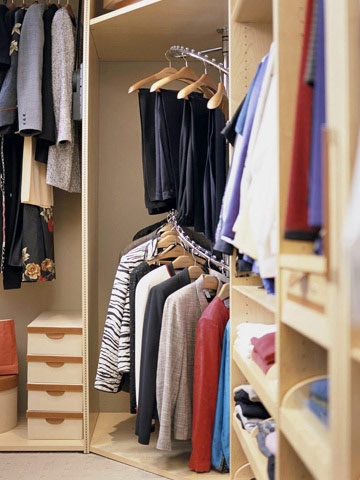 an organized closet with clothes hanging on the shelves and shoes in the bins next to it