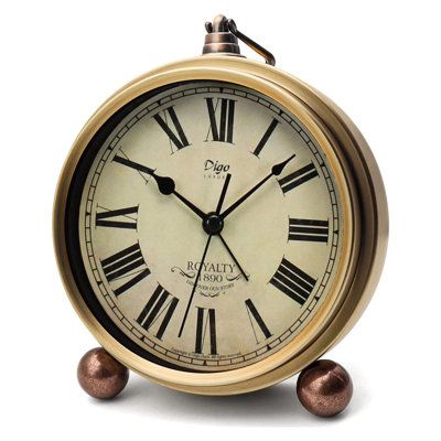 an old fashioned clock with roman numerals on the face and two balls around it