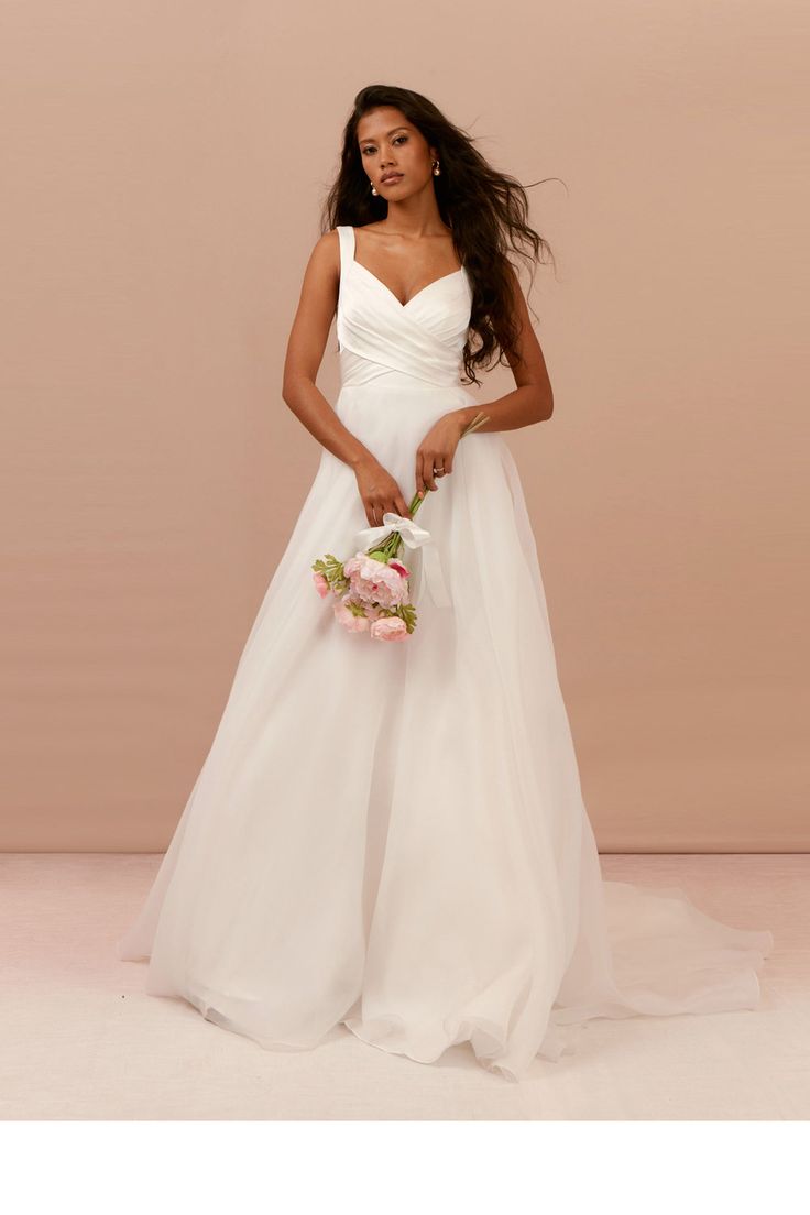 a woman in a white wedding dress holding a bouquet