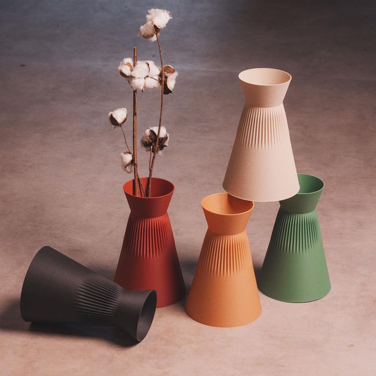 three different colored vases with flowers in them