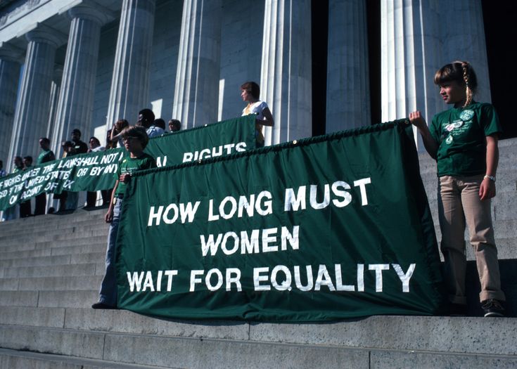 people standing on the steps holding signs that read how long must women wait for equality