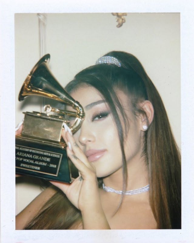 a woman holding an award in front of her face