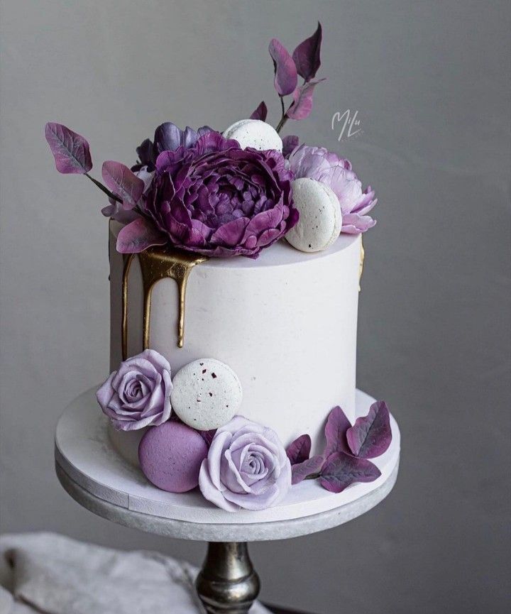 there is a white cake with purple flowers on the top and eggs in the middle