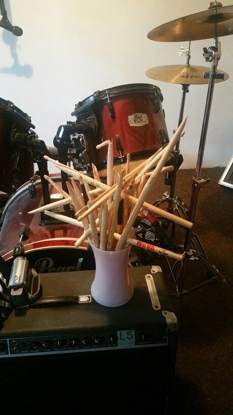 a drum set with sticks sticking out of the top and drums on the floor behind it